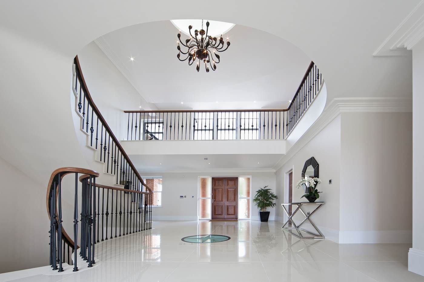 Double-height galleried hallway with a curved staircase
